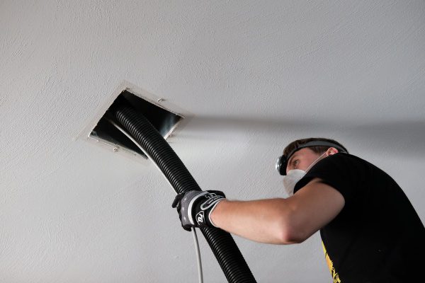 A Technician gets deep into the air ducts to clean years of dust and debris