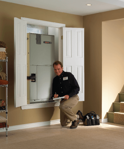 A technician checks an AC maintenance task off his list