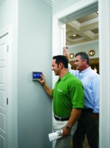 A Tech shows a Denton homeowner the basics of his new AC Control