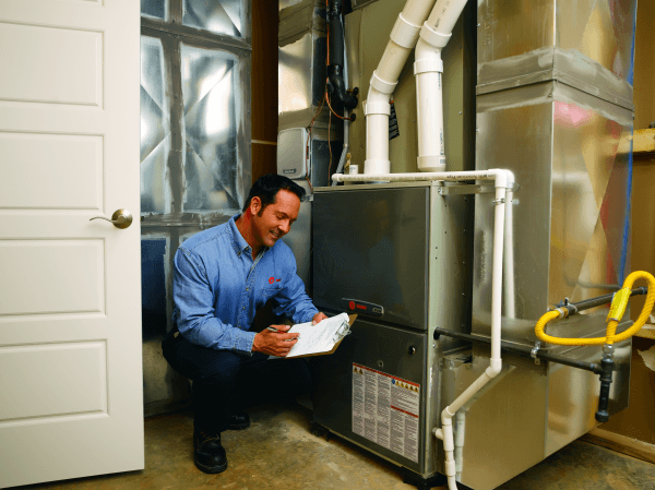 A technician checks on a heater